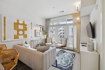 a living room with a white couch and a large window at Link Apartments® Broad Ave, Memphis
